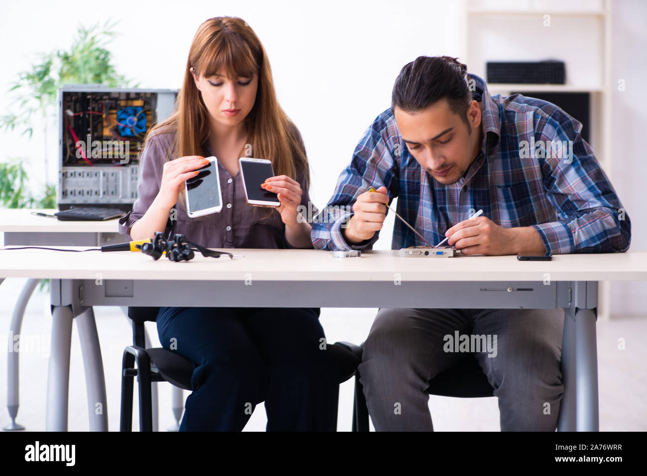 The two technicians working at computer warranty center Stock Photo