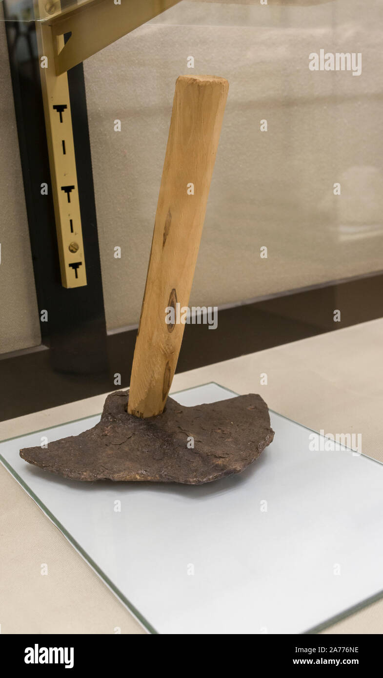 Montilla, Spain - March 2nd, 2019: Roman hoe. Agricultural iron tool with replica wooden handle and original wide head. Montilla Local History Museum, Stock Photo