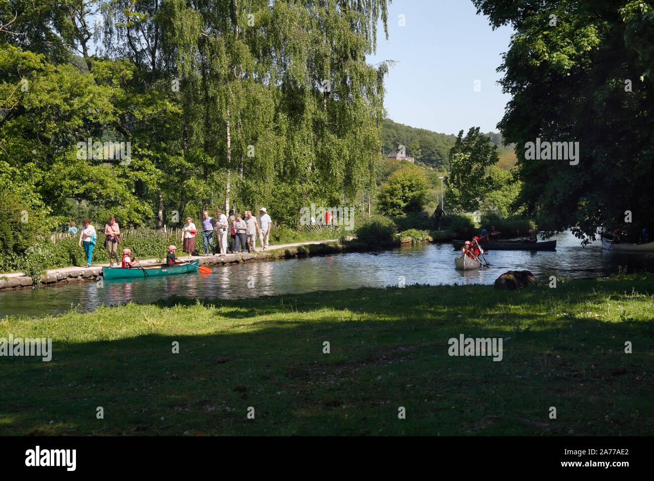 People walking alongside the Cromford Canal and Children canoeing Derbyshire England UK leisure activity restored waterway Stock Photo