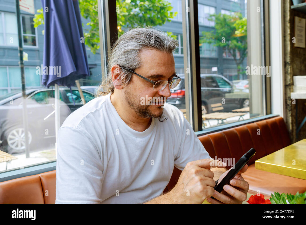 Man looking at his hands with smartphone texting message or dialing in office Stock Photo