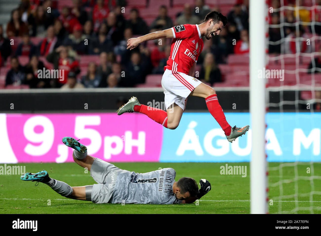 Lisbon, Portugal. 30th Oct, 2019. Pizzi (Top) of Benfica jumps over Portimonense's goalkeeper Ricardo Ferreira during their Portuguese League football match at the Luz stadium in Lisbon, Portugal, on Oct. 30, 2019. Credit: Pedro Fiuza/Xinhua/Alamy Live News Stock Photo