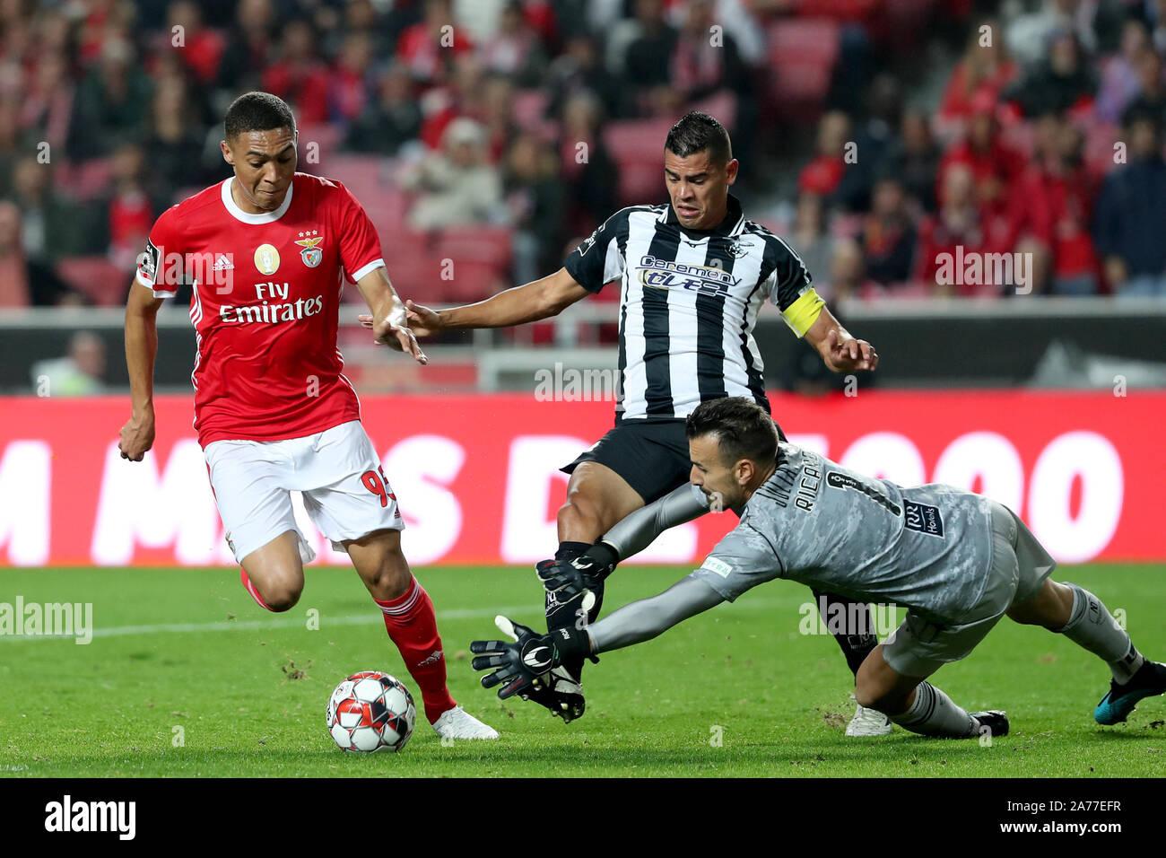 Lisbon, Portugal. 30th Oct, 2019. Carlos Vinicius (L) of Benfica vies with Portimonense's Jadson (C) and goalkeeper Ricardo Ferreira during their Portuguese League football match at the Luz stadium in Lisbon, Portugal, on Oct. 30, 2019. Credit: Pedro Fiuza/Xinhua/Alamy Live News Stock Photo