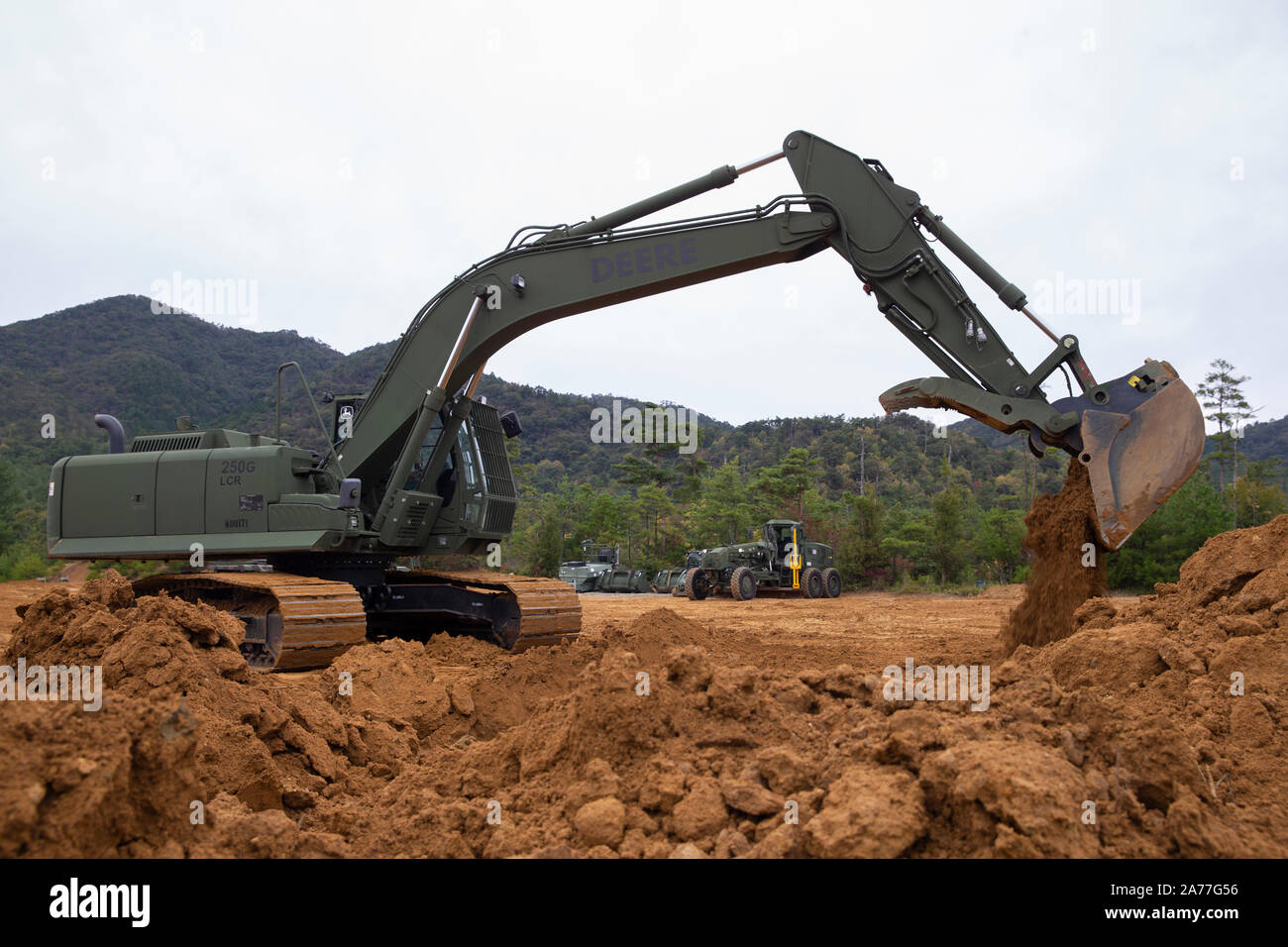A U.S. Marine Corps Hydraulic Excavator digs a hole for a fortified bunker during Defense Force Training 20.1, at the Japan Ground Self-Defense Force Haramura Maneuver Area, Hiroshima, Japan, Oct. 21, 2019. Exercises like DFT 20.1 provide realistic training to Marines with MWSS-171, where they hone their skills and remain mission ready while being forward-postured in the Indo-Pacific. (U.S. Marine Corps photo by Lance Cpl. Tyler Harmon) Stock Photo