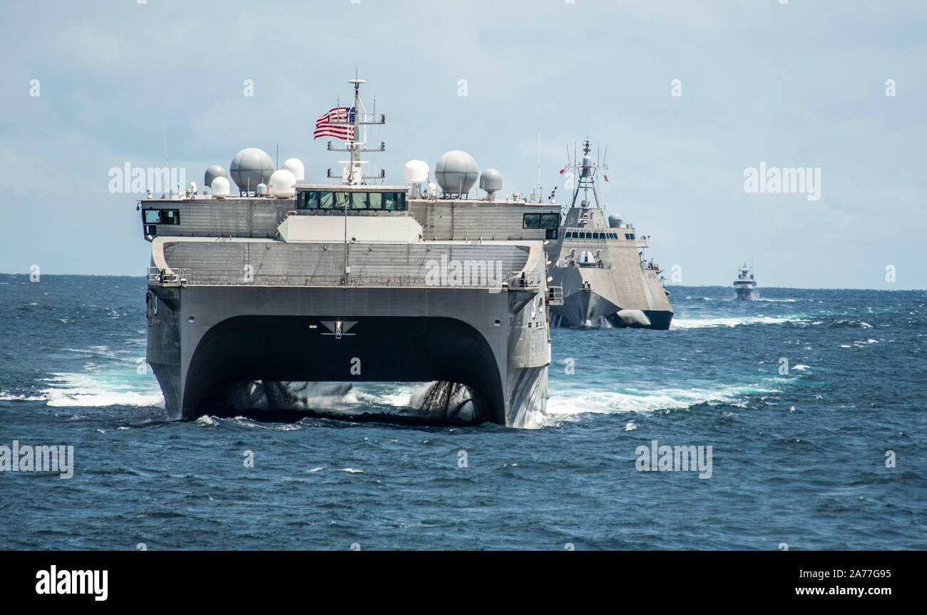 191029-N-FV739-0263  SOUTH CHINA SEA (Oct. 29, 2019) The Spearhead-class expeditionary fast transport USNS Millinocket (T-EPF 3), Independence-variant littoral combat ship USS Montgomery (LCS 8) and Royal Brunei Navy inshore patrol vessel KDB Syafaat (SYA 19) assemble in formation for a photo exercise (PHOTOEX) in support of Cooperation Afloat Readiness and Training (CARAT) Brunei. This year marks the 25th iteration of CARAT, a multinational exercise designed to enhance U.S. and partner navies' abilities to operate together in response to traditional and non-traditional maritime security chall Stock Photo