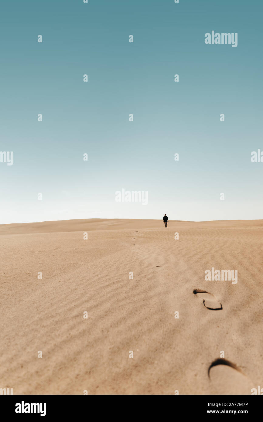 Person walks around around on a Sand Dune Desert Stock Photo