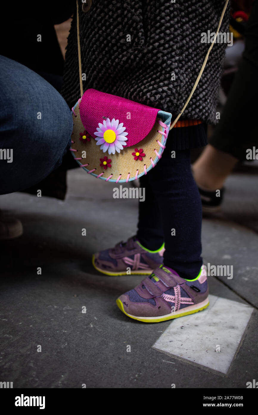 Baby shoes and bag on a little girl close up still urban shot Stock Photo