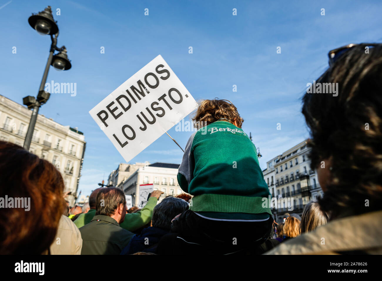 A child holding a placard during the demonstration. Thousands of people gathered at Puerta del Sol to protest against precariousness and low pensions for elder people. Marches from Bilbao (northern Spain) and Rota (southern Spain) met at the country's capital to protest in front of Spanish Parliament. Stock Photo