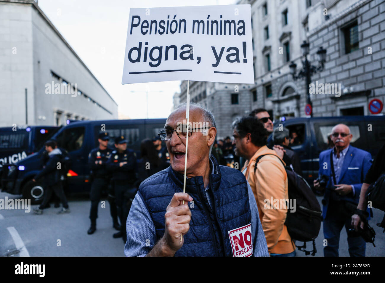 An old man holds a placard during the demonstration. Thousands of people gathered at Puerta del Sol to protest against precariousness and low pensions for elder people. Marches from Bilbao (northern Spain) and Rota (southern Spain) met at the country's capital to protest in front of Spanish Parliament. Stock Photo