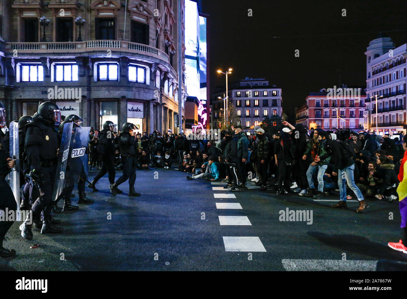 Spanish riot police charge on demonstrators at the Gran VÌa street during the clashes. Hundreds of far left protesters clashed with police after a pacific rally against the Supreme Court sentence of Catalan politics and activists. They were more than ten detentions and some police officers were injured. In an attempt of recreating the violent riots of Barcelona the protesters settled up barricades in some streets of city centre. Stock Photo
