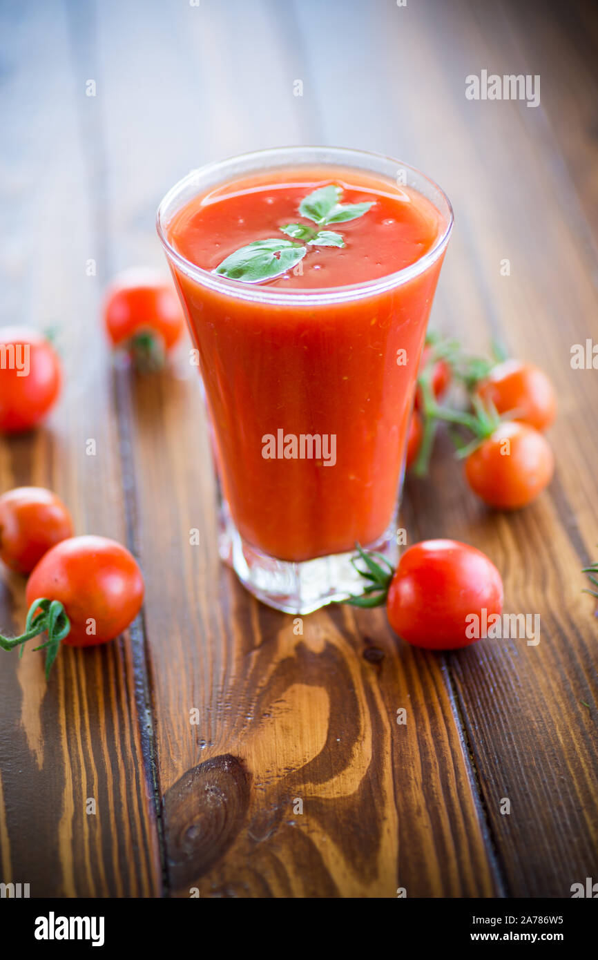 homemade tomato juice in a glass and fresh tomatoes Stock Photo