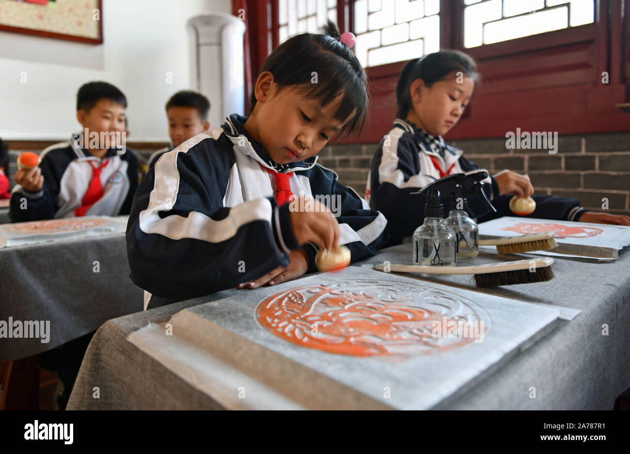 Jinan, China's Shandong Province. 30th Oct, 2019. Pupils of Xixian primary school experience the art of rubbing at Lubei intangible cultural heritage experiencing center in Wudi County, east China's Shandong Province, Oct. 30, 2019. The experiencing center provides a variety of intangible cultural heritage experiencing programs, including the arts of rubbing, ceramics, tie dyeing, paper-making and movable-type printing, aiming to promote traditional Chinese culture through immersive experience. Credit: Zhu Zheng/Xinhua/Alamy Live News Stock Photo