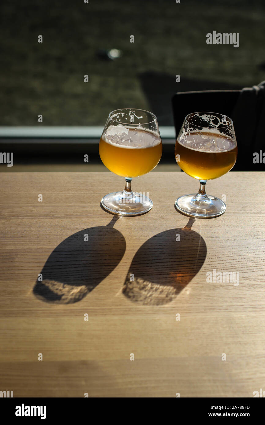 Two snifter glass with beer on the sun on the table Stock Photo Alamy