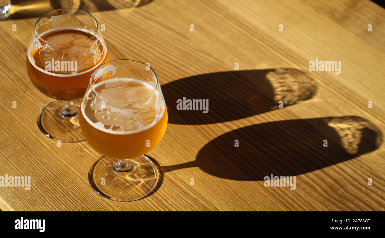 Two snifter glass with beer on the sun on the table Stock Photo Alamy