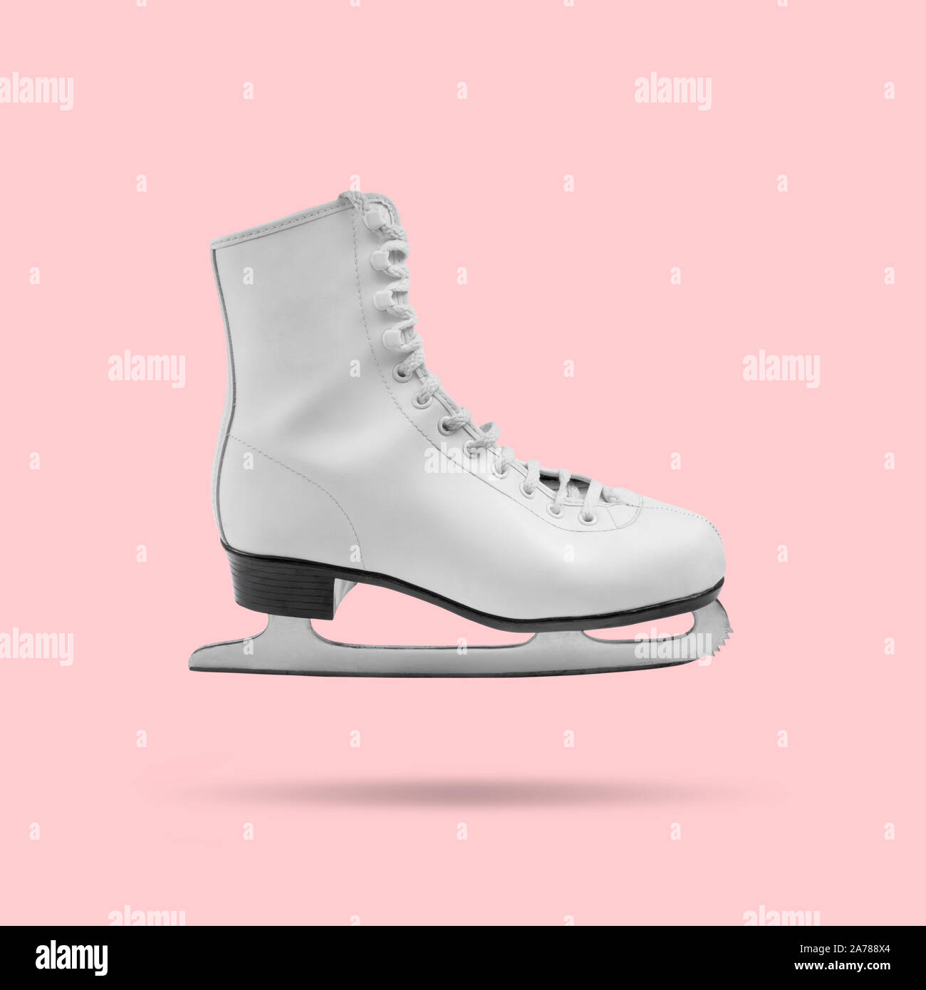 Floating white ice skate on pink background, minimal design Stock Photo