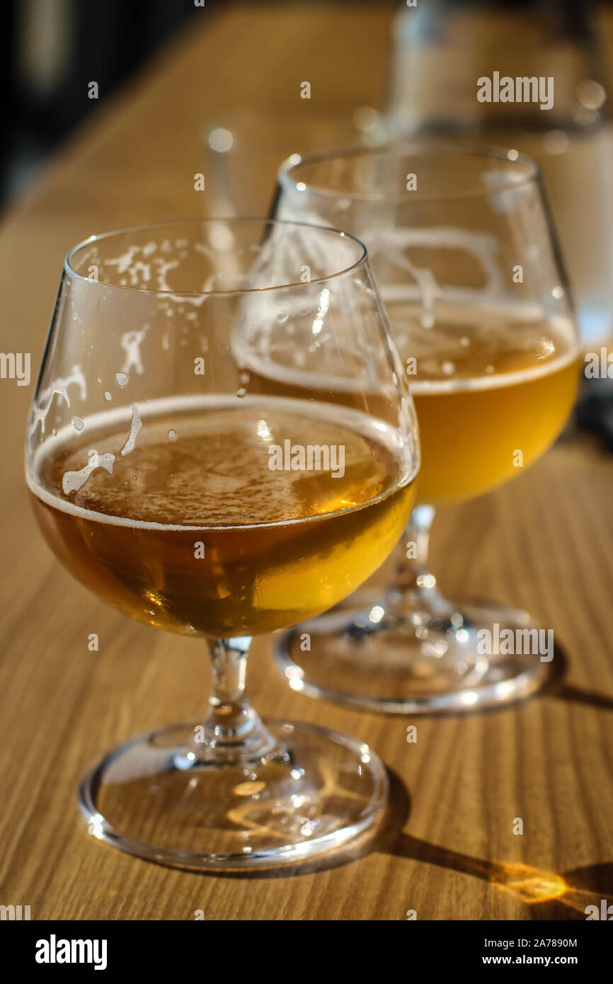 Two snifter glass with beer on the sun on the table Stock Photo Alamy