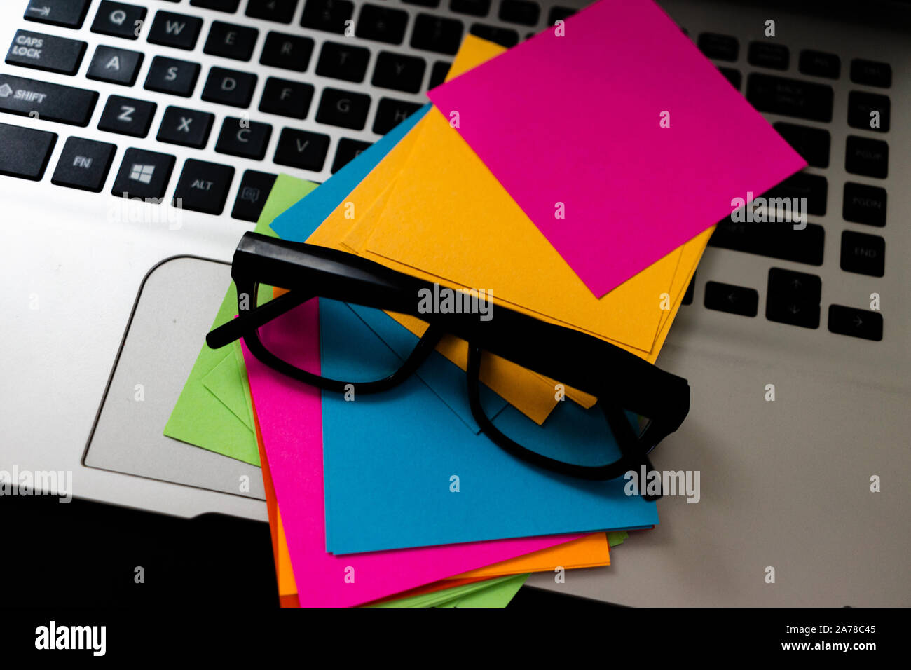 Colorful sticky notes with glasses on keyboard. Stock Photo