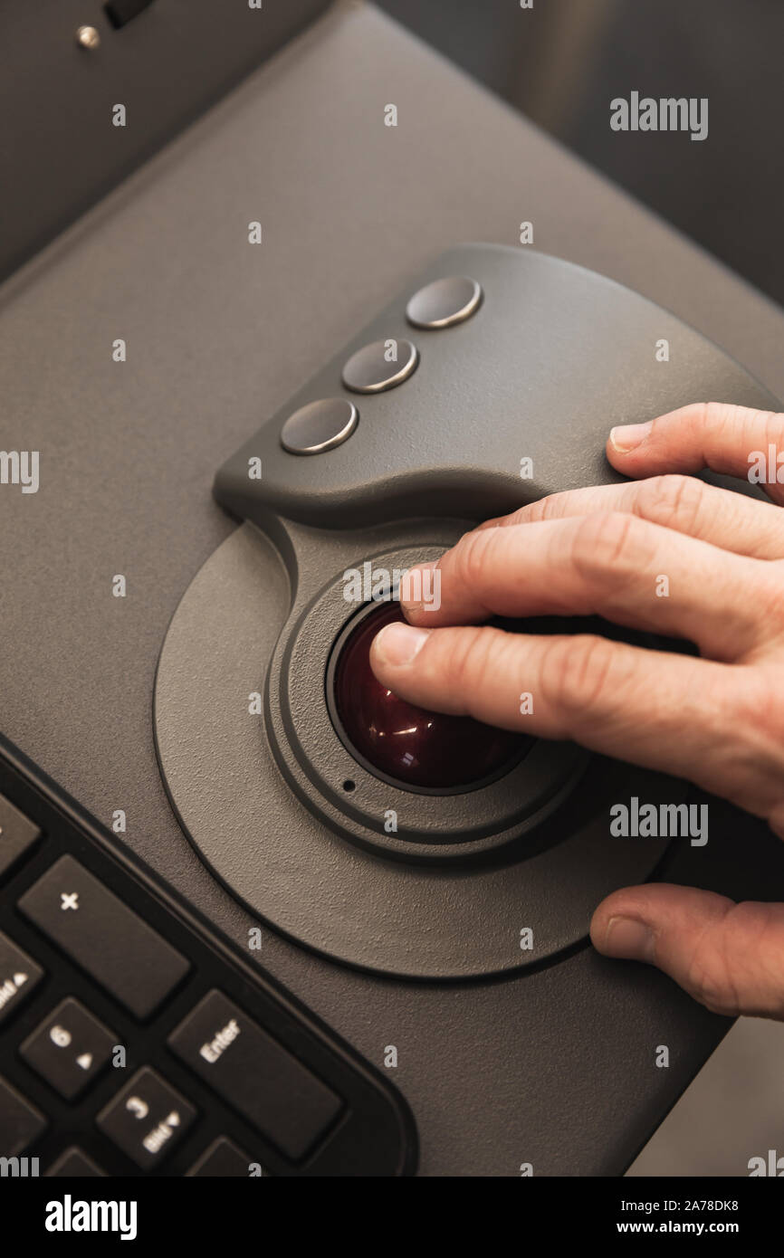 Industrial control panel made of gray metal with operators hand on a trackball, close up photo with soft selective focus Stock Photo