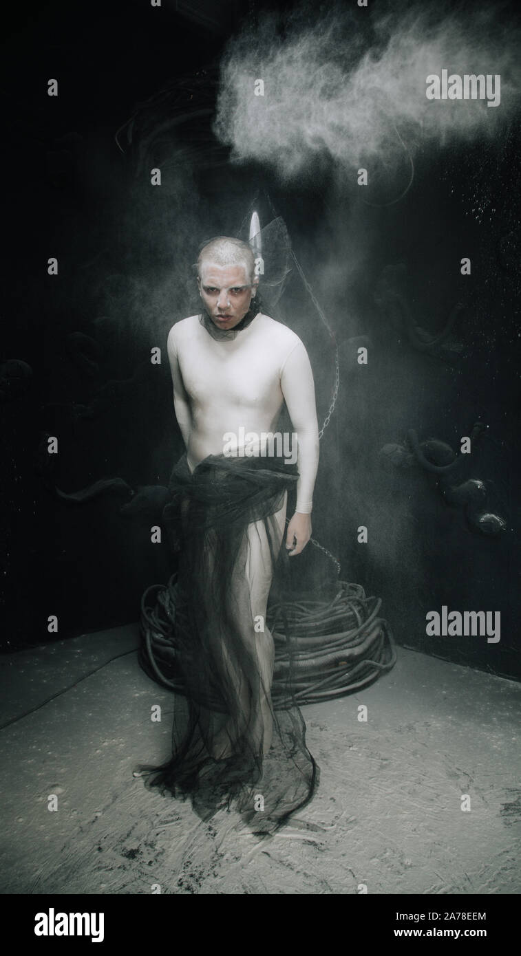 strange guy in tight beige leotard with dust on black studio background. Stock Photo