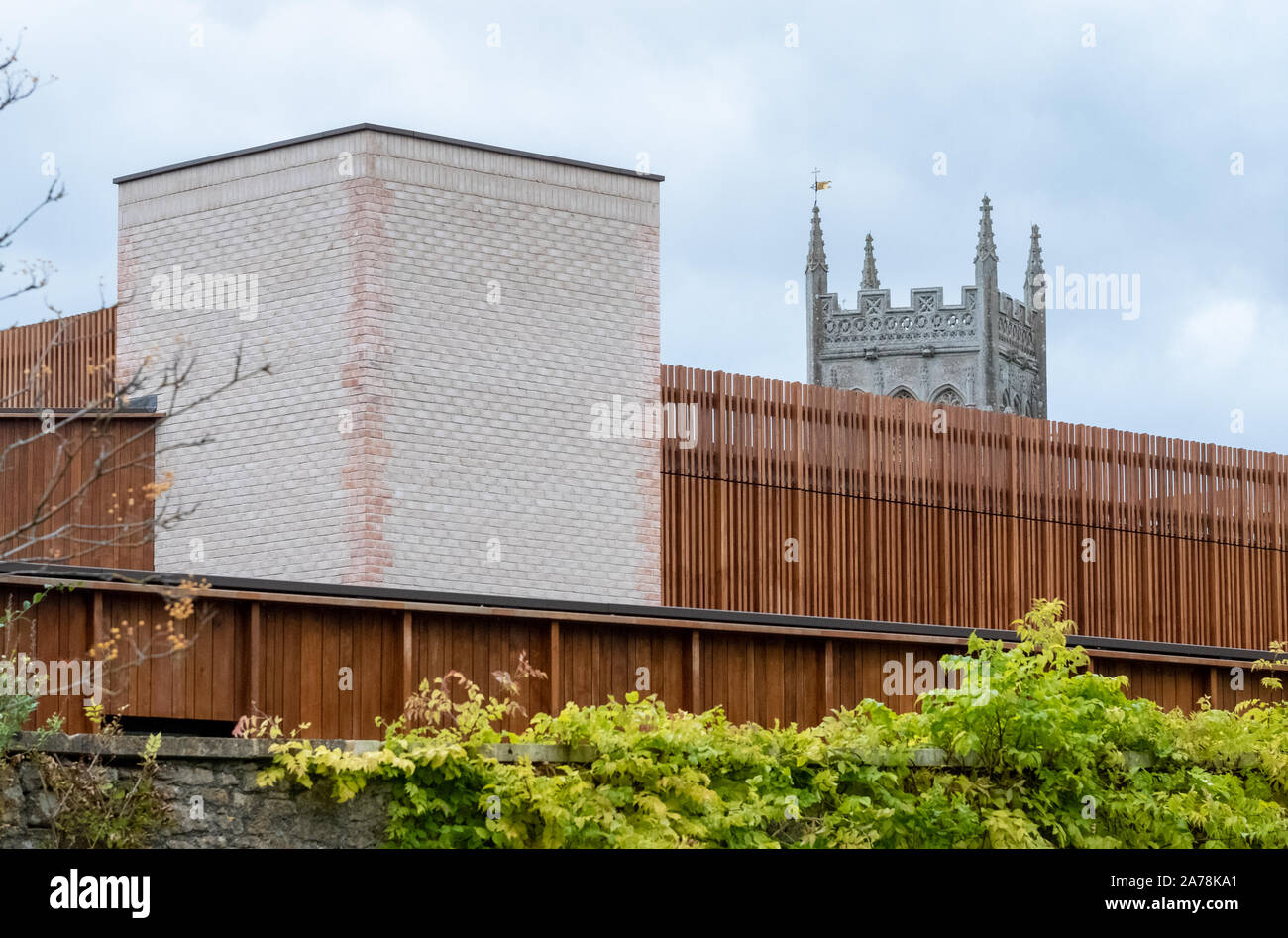 The new Queen Elizabeth Music School at King's Bruton school In Somerset. Building designed by Levitt Bernstein. Tower of St Mary's Church in distance Stock Photo