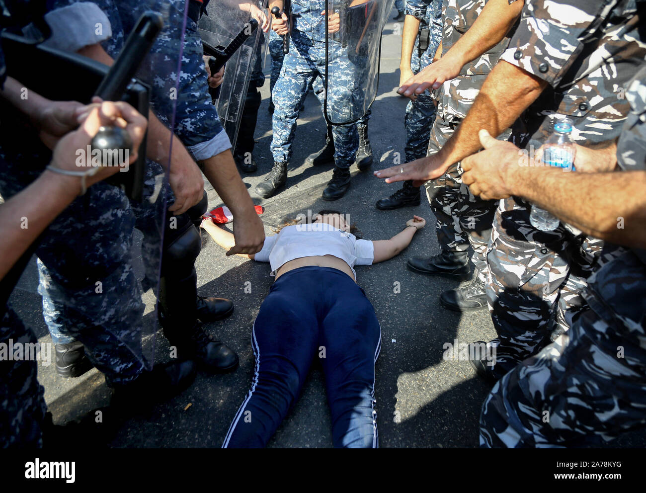Beirut, Lebanon. 31st Oct, 2019. A protestor lies on the ground after she fainted while riot police evacuating demonstrators after blocking a vital road. Credit: Marwan Naamani/dpa/Alamy Live News Stock Photo