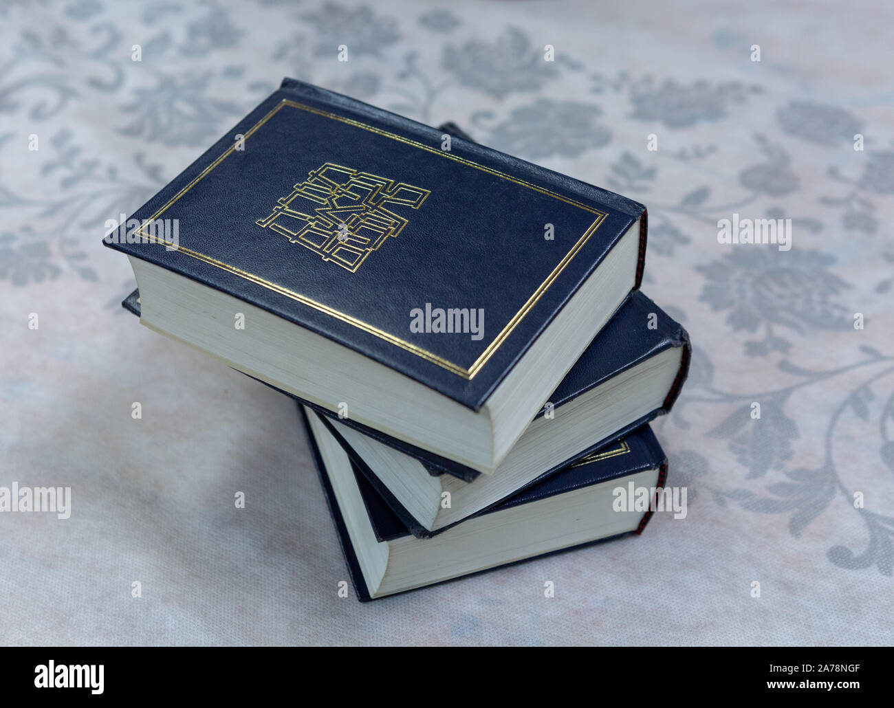 Several books of Torah are lying on the tablecloth. Stock Photo