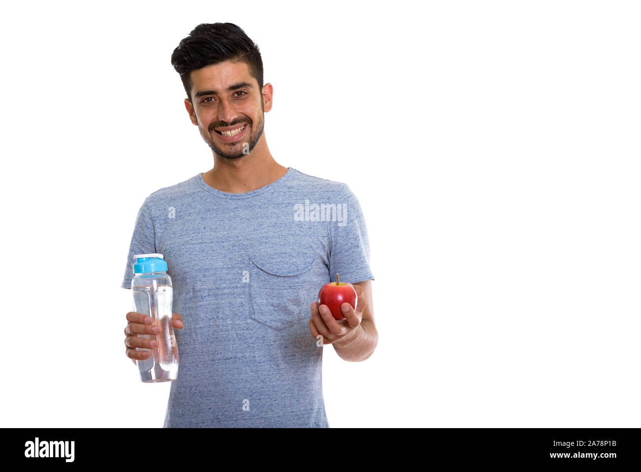 Happy Persian man smiling while holding red apple and water bottle ...