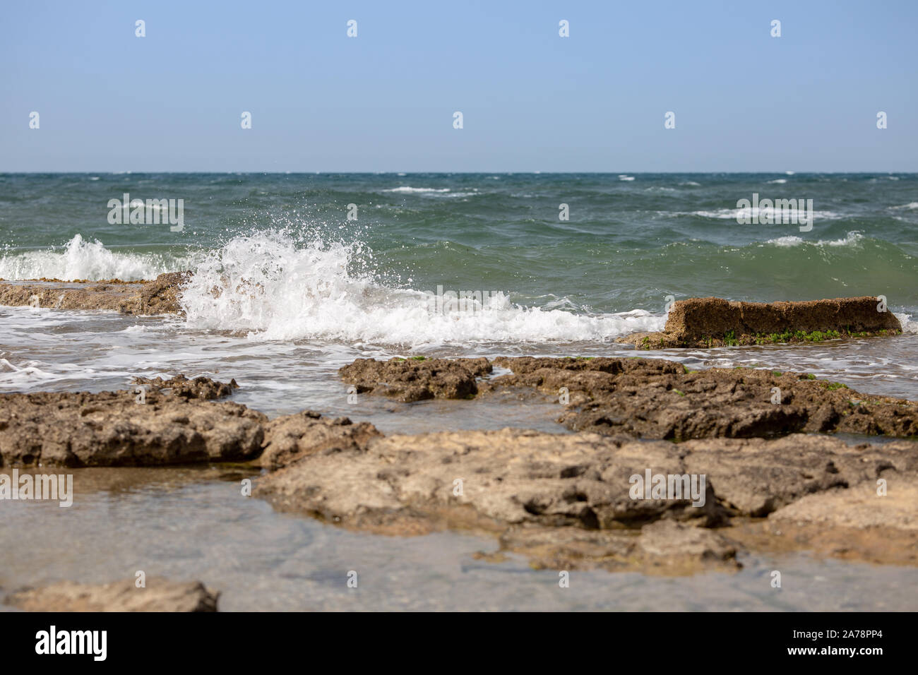 Sea waves and the ruins of the ancient port Stock Photo