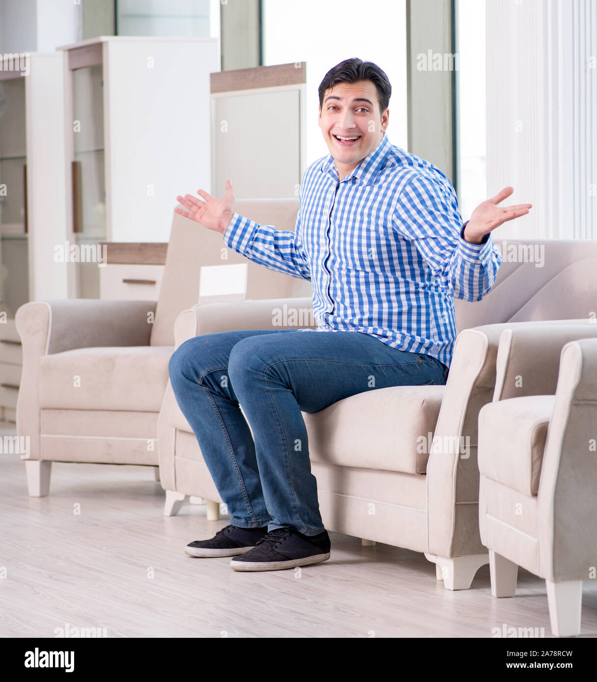 The young man shopping in furniture store Stock Photo - Alamy