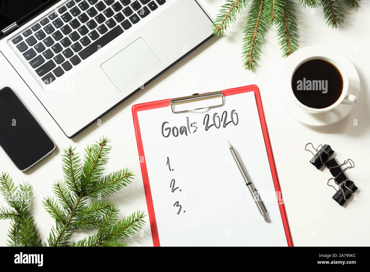 2020 New Year goals, planning, dreams and wishes. Office workplace with laptop, fir branches on white background. Top view with copy space. Stock Photo