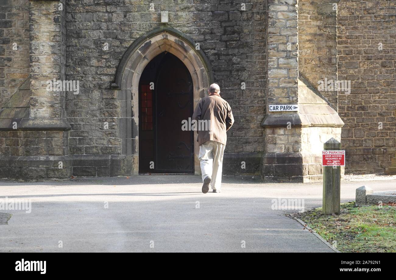 A man enters The Church of the Annunciation in New Mills, Derbyshire