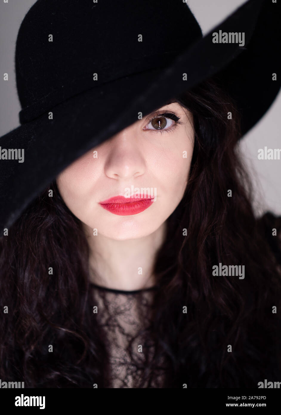 Beautiful young woman wearing black hat Stock Photo - Alamy