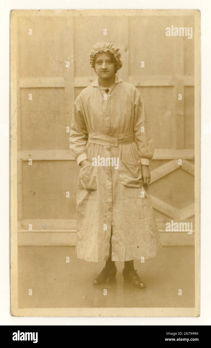 Original WW1 era postcard portrait of female munitions / weapons manufacturers worker wearing 'on war service' badge on her uniform, wearing a mob cap, in Hunstanton, Norfolk, England, Britain, U.K. 1916-1918 Stock Photo