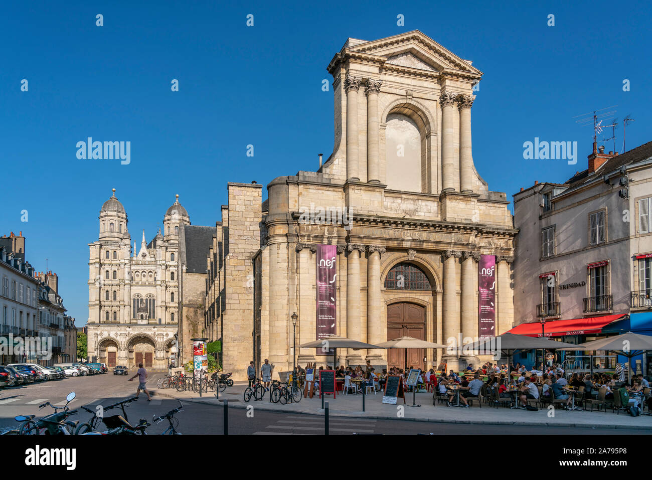Cafe in front of the Nave of the Church of Sainte Bernadette, Central library, Place of Theatre, background Saint Michel church, Dijon, Burgundy, Fran Stock Photo