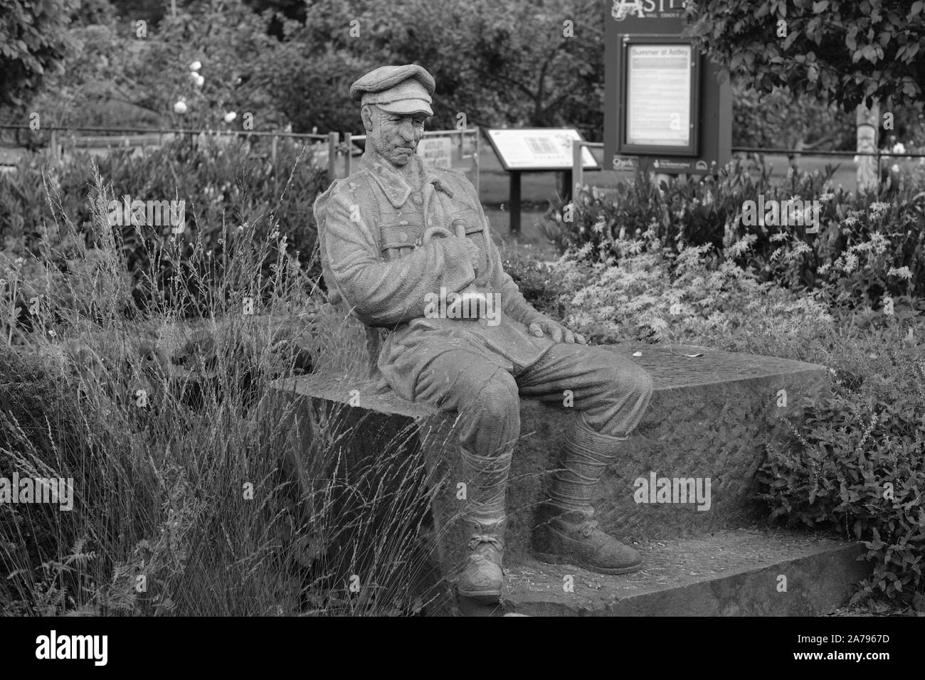 modern stone statue of seated WW1 soldier resting in the garden at Astley Hall, Chorley Stock Photo