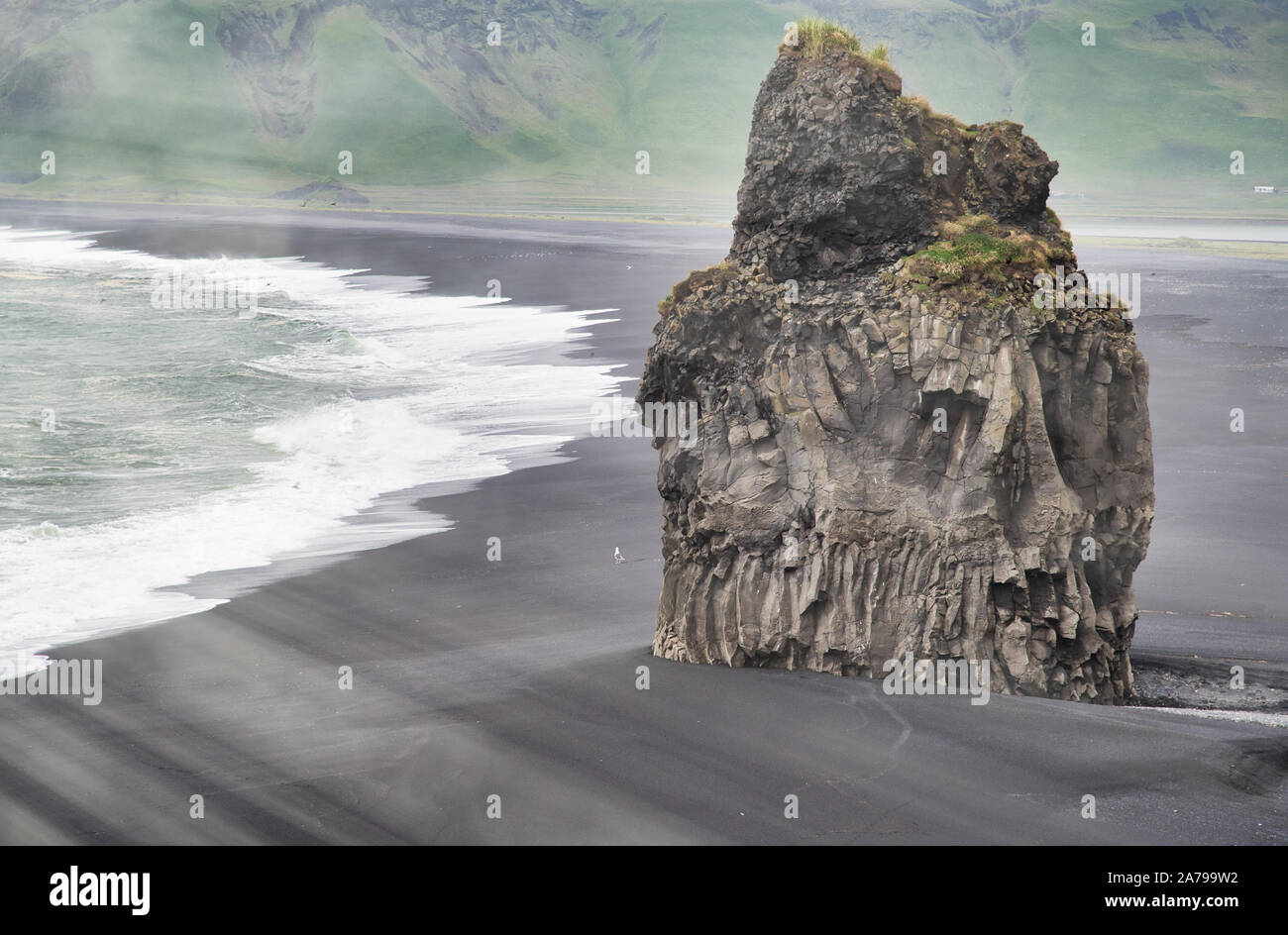 Giant Rock in Reynisfjara Black Beach on a cloudy summer morning, Iceland. Stock Photo