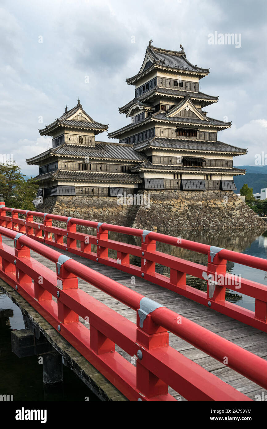 Matsumoto Castle (Crow Castle) with red bridge over the moat. Matsumoto Castle is one of Japan's most important historic castles. Stock Photo