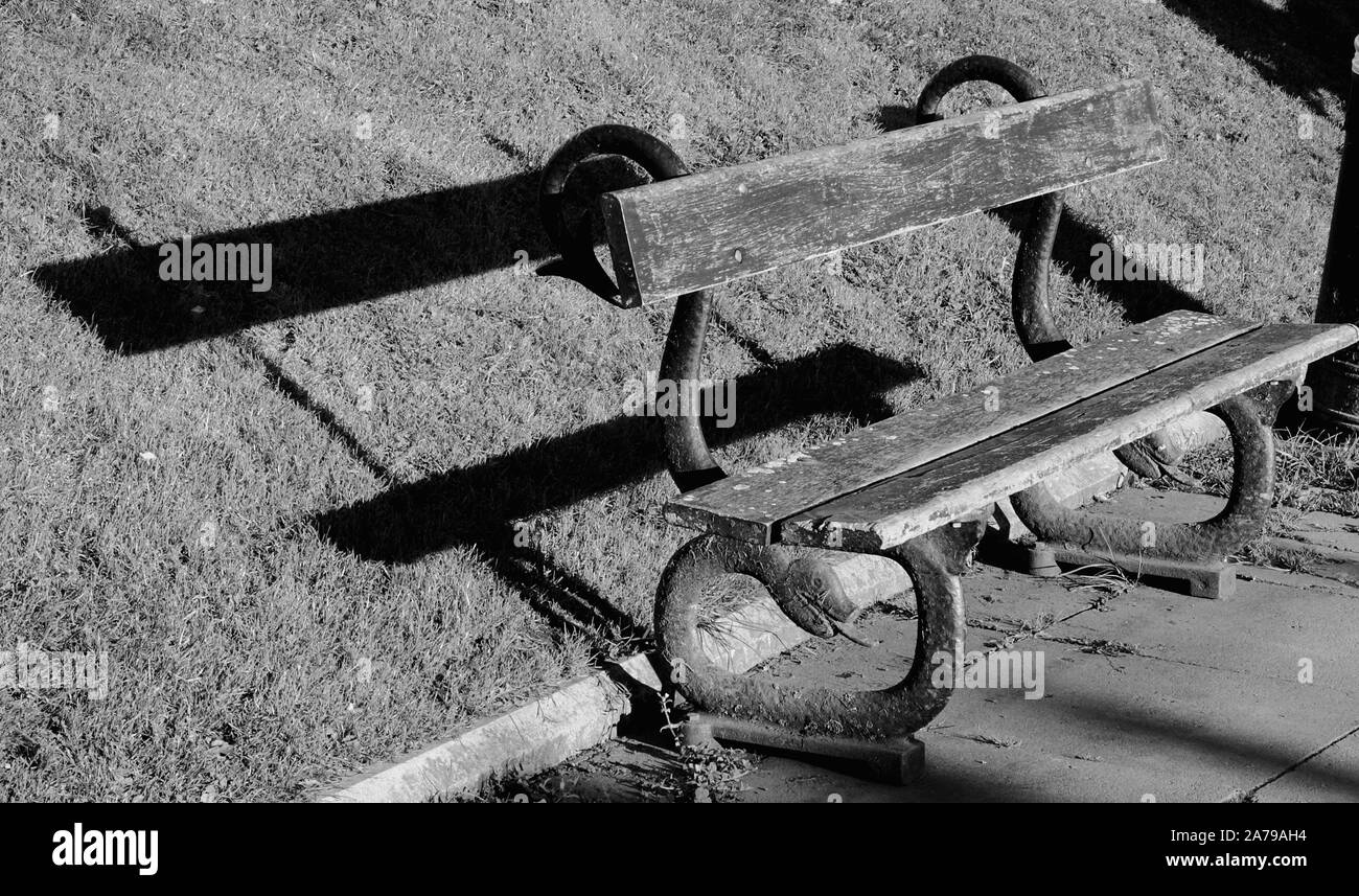 Old park bench with a shadow Stock Photo