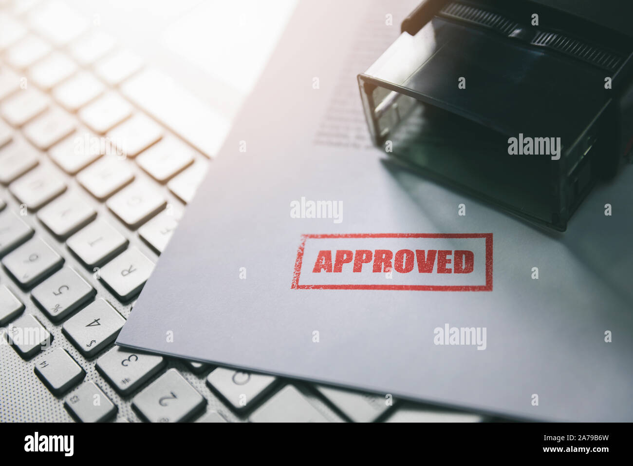 document with approved stamp on computer keyboard Stock Photo