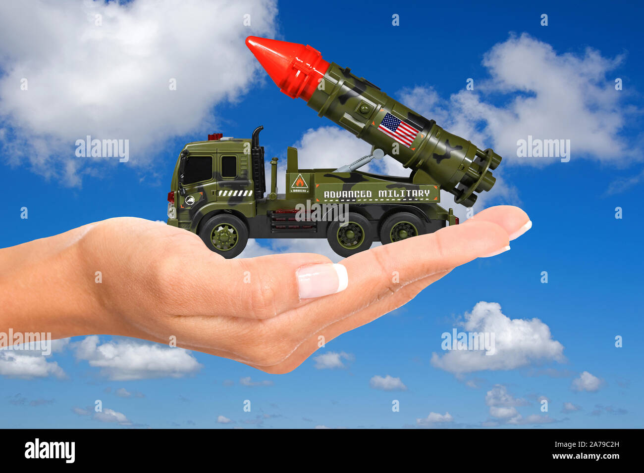 Hand mit Modellauto, LKW, Frauenhand, Raketenwerfer, Kriegsspielzeug, Rakete, Krieg, Stock Photo