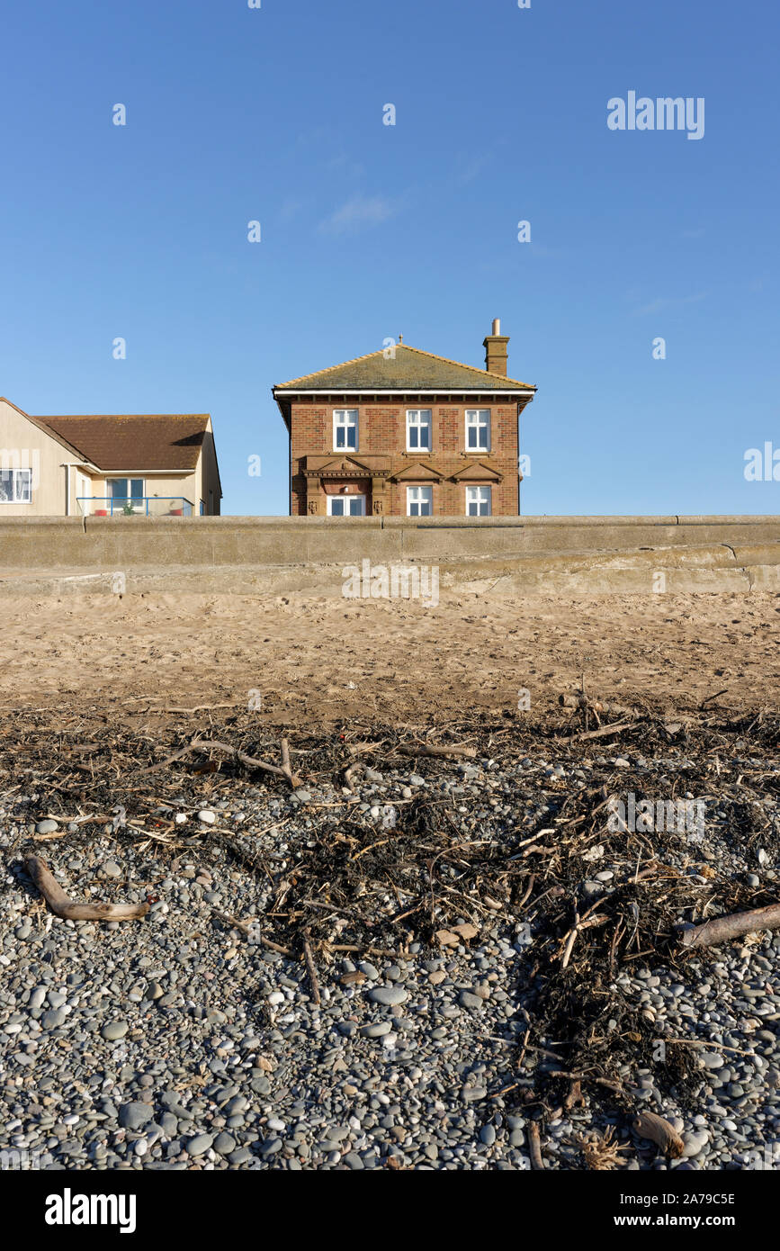 Beach and concrete seawall protecting houses on seafront in rossall on