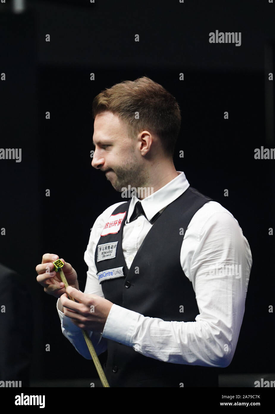 Judd Trump of England chalks his cue as he considers a shot to Ben Woollaston of England in their second round match during the 2017 Shanghai Masters Stock Photo