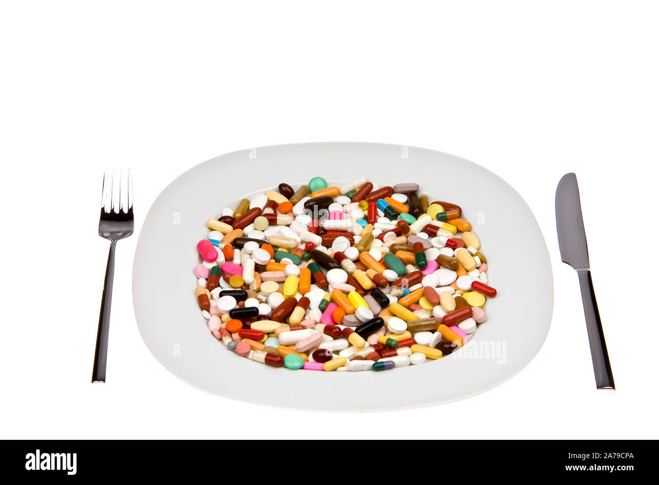 Verschiedene bunte Tabletten auf einem Teller angerichtet als Mittagessen, Symbolbilder Stock Photo