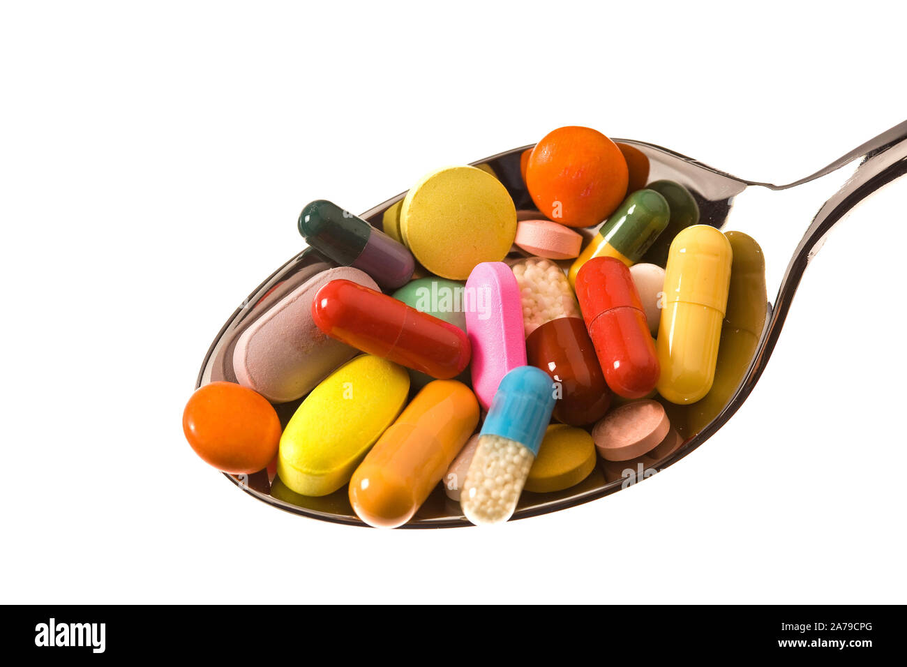 Auf einem Löffel liegen viele bunte Tabletten,  Tablettensucht, Medikamentensucht, Abhängigkeit, Stock Photo