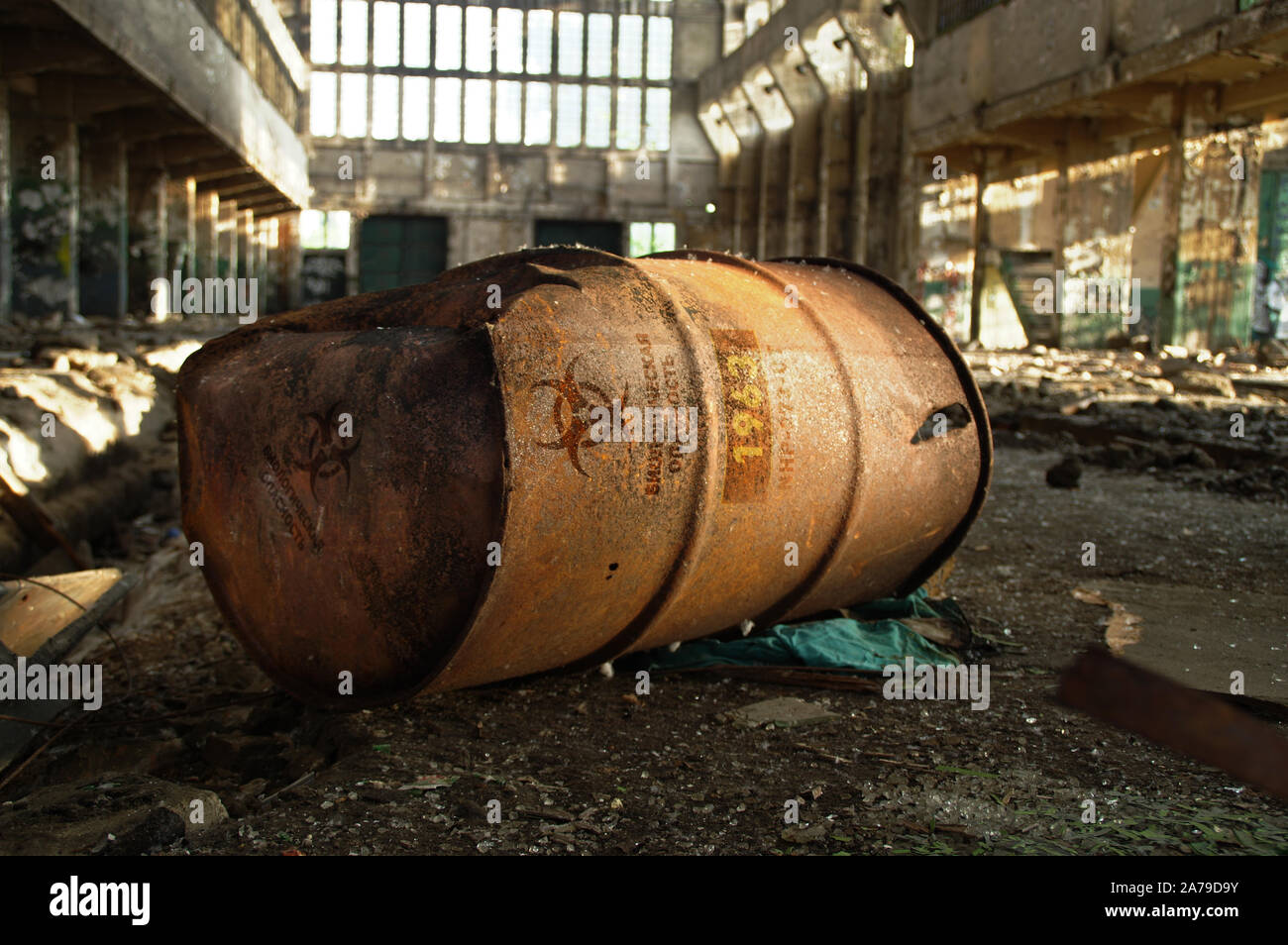 Radioactive warning on old rusty barrel in destroyed and forgotten building. Radiation symbol with russian alert on waste container after nuclear disa Stock Photo