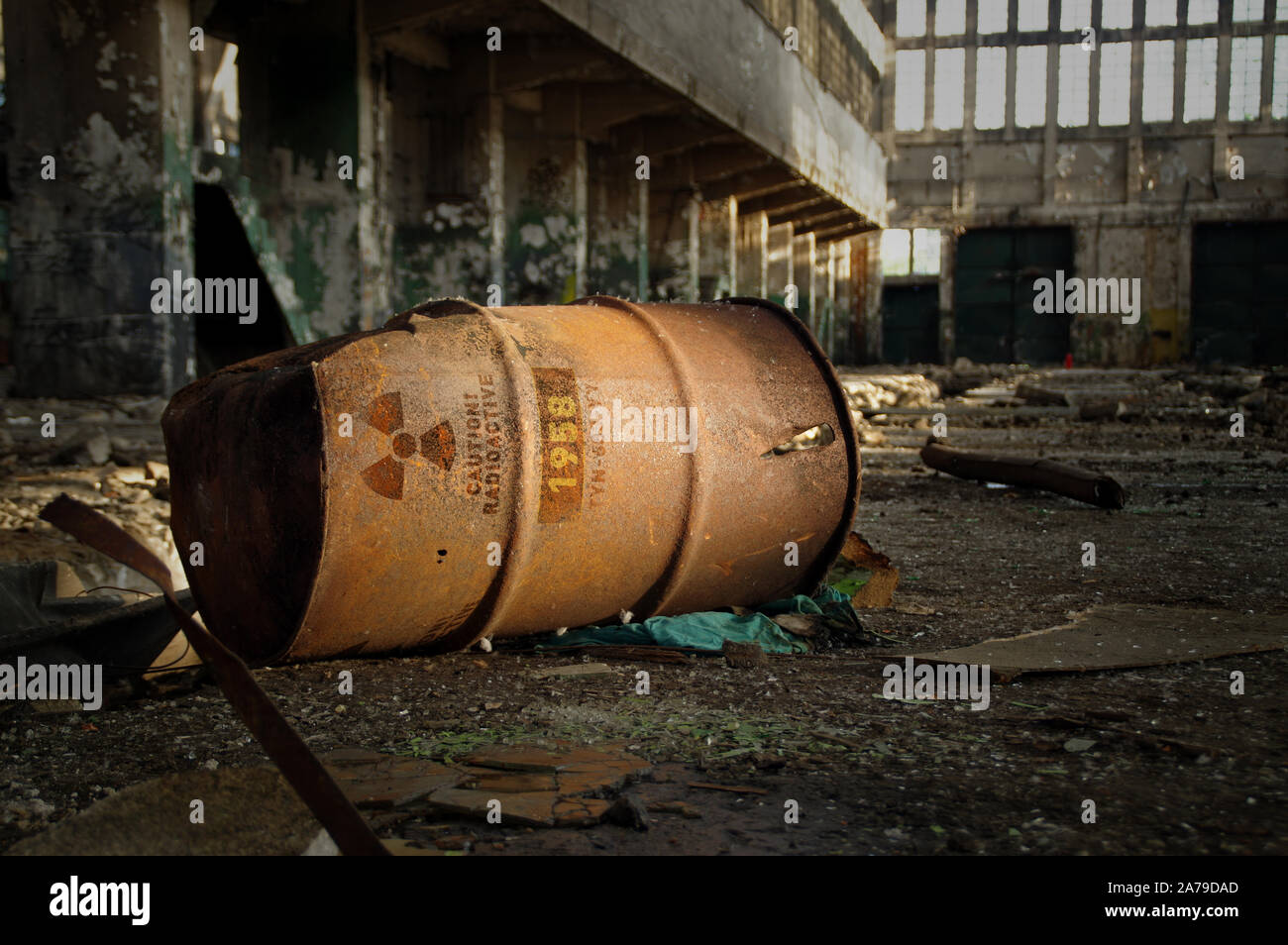 Radioactive warning on old rusty barrel in destroyed and forgotten building. Radiation symbol with alert on waste container after nuclear disaster. 3D Stock Photo