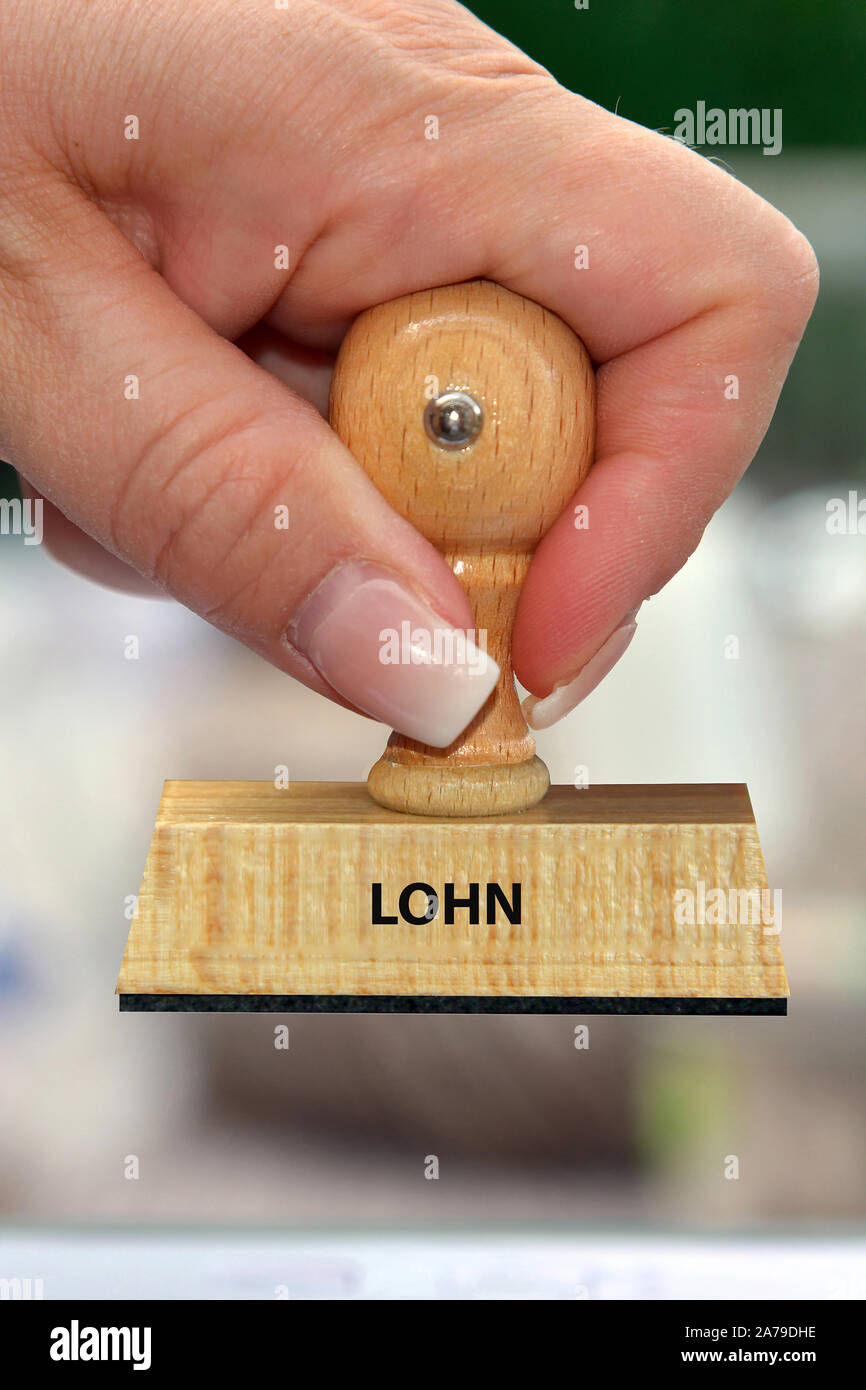 Hand mit Stempel, Frauenhand, Aufschrift: Lohn, Stock Photo