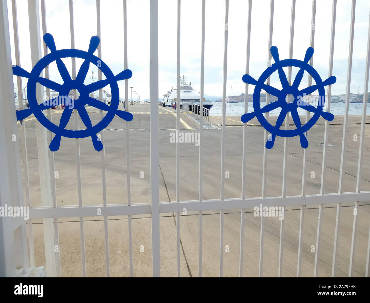 view of the port through the white entrance gates depicting two blue ...