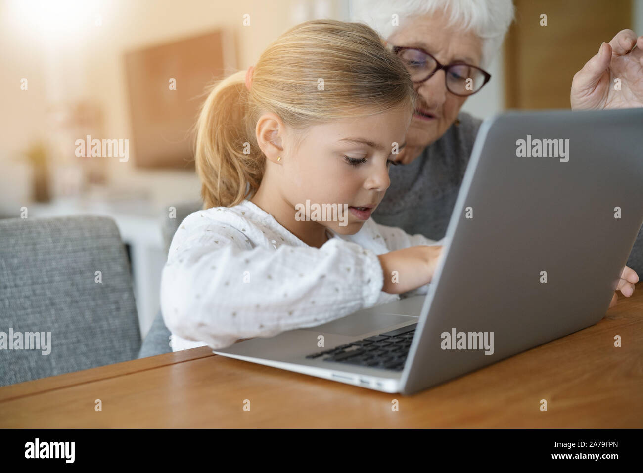 Little girl with grandmother using laptop computer Stock Photo - Alamy