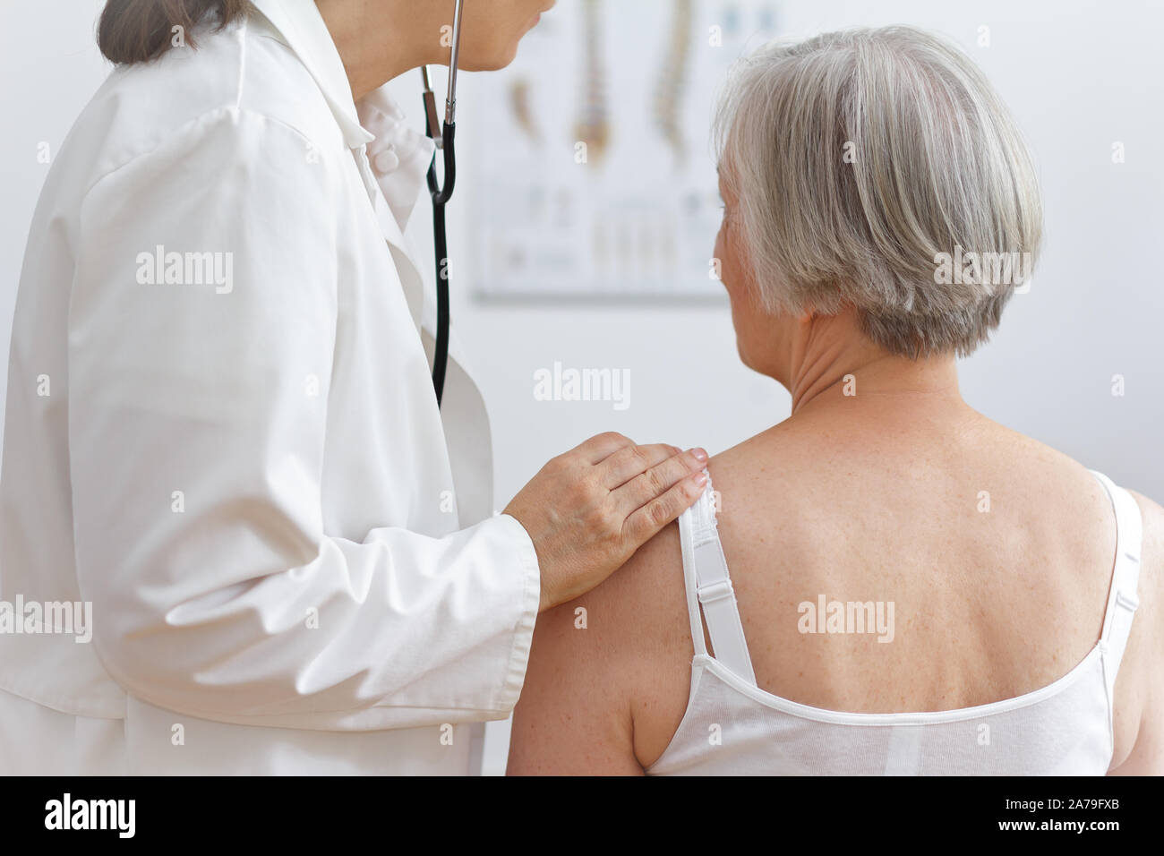 Health care concept: female doctor auscultating the heart of a senior patient with a stethoscope. Stock Photo