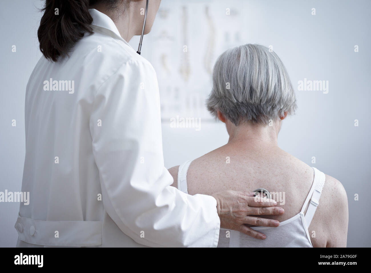 Health care concept: female doctor auscultating the lungs of a senior ...